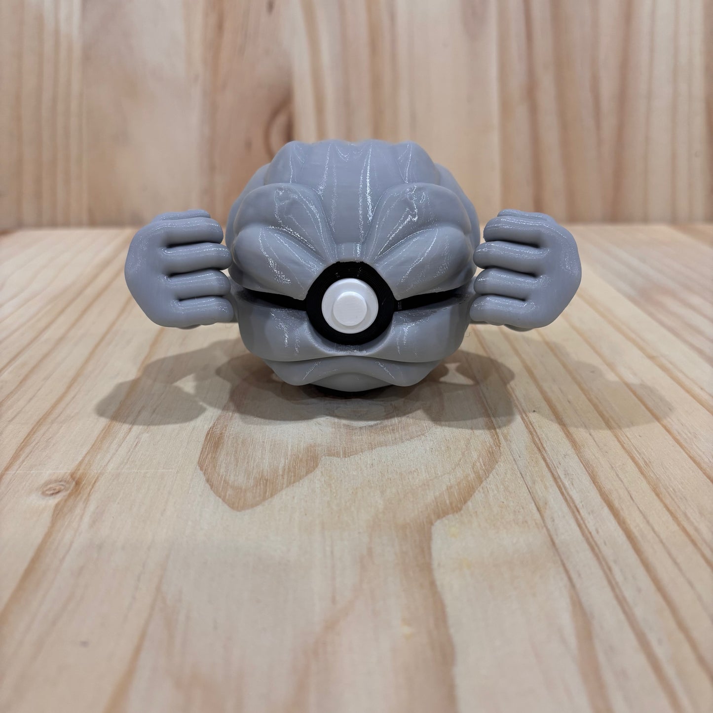 3D printed 0074 Geodude Poké Ball collectible inspired by Geodude featuring its rocky body and signature muscular arms.