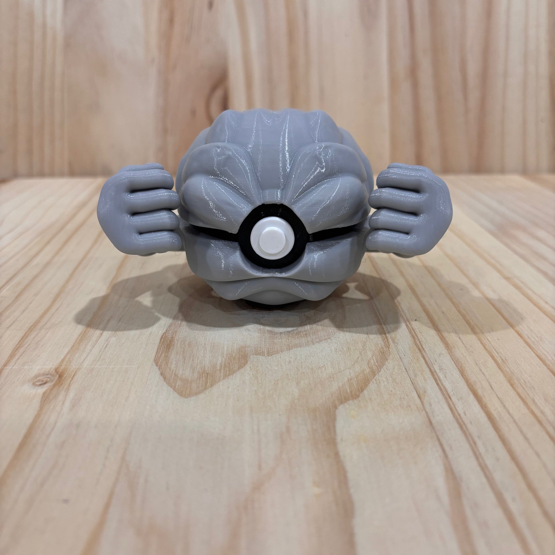 3D printed 0074 Geodude Poké Ball collectible inspired by Geodude featuring its rocky body and signature muscular arms.