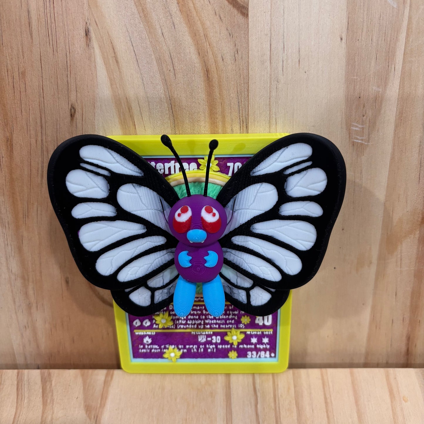 3D printed 0012 Butterfree Pokémon Card Display featuring a detailed Butterfree figure mounted on a Pokémon-inspired trading card backdrop.