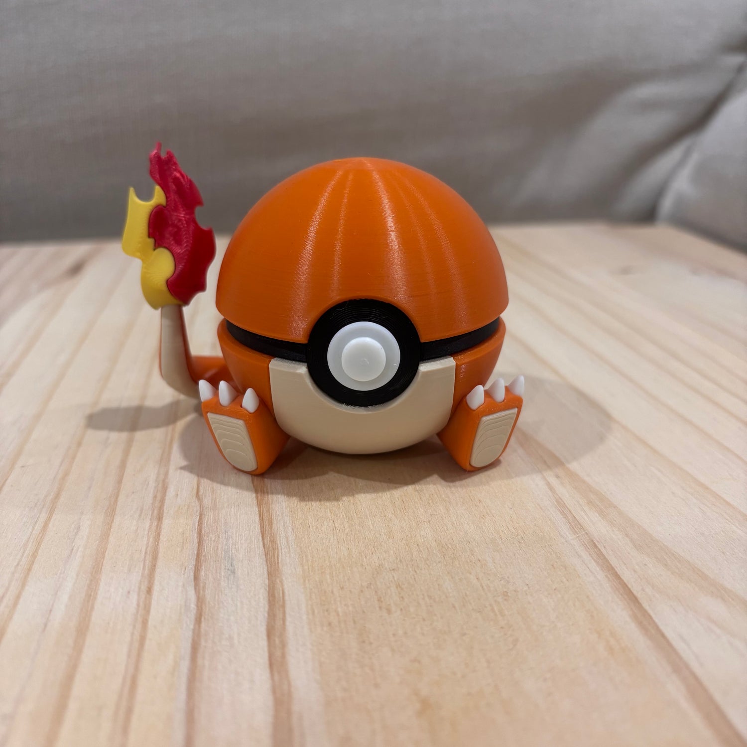 3D printed 0004 Charmander Poké Ball collectible inspired by Charmander featuring its iconic flame tail and orange colour scheme.